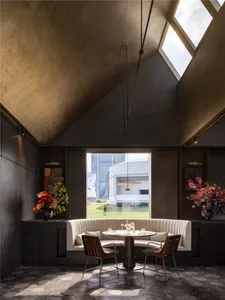 Inviting restaurant interior with tables, chairs, and potted plants, perfect for a meal