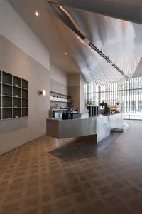 A modern kitchen with two ovens, a sink, refrigerator, and various kitchen items, with a clean and organized atmosphere