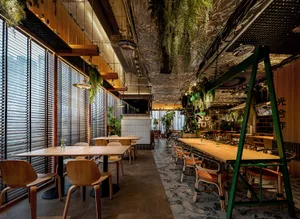 Warm and inviting dining space with a large wooden table, multiple chairs, and potted plants