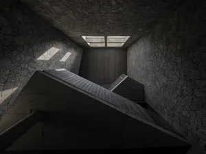 A dark and moody staircase with concrete stairs and no natural light