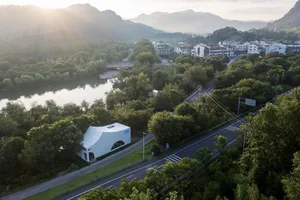 A serene architectural scene featuring a modern and traditional building with a large dome next to a river, surrounded by trees