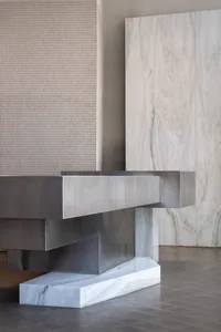 A modern interior space with a large stainless steel countertop, clean lines, and a minimalist aesthetic