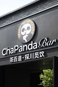 Modern Asian restaurant with a concrete exterior and a black sign with white lettering