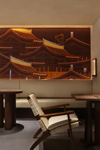 Warm and inviting interior space with a large Japanese-inspired mural, wooden furniture, and a dining table