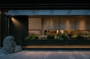 Elegant living space with a black and white color scheme, featuring potted plants, vases, and a well-organized atmosphere
