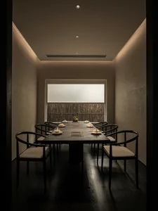 A cozy dining area with a wooden table and chairs, set with white plates, creating an inviting atmosphere for guests