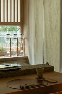 A calm kitchen scene with a sink, window, and wine glasses on a countertop