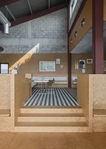 Dining area with wooden walls, two tables, and chairs, featuring a warm and inviting atmosphere