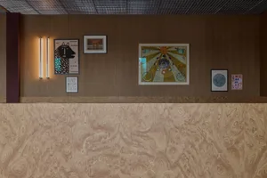A well-lit interior design showroom with wooden walls and ceilings, decorated with artwork and a picture of a dog, creating a cozy and sophisticated atmosphere