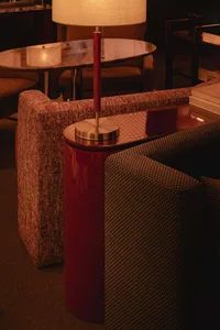 Cozy living area with a red table lamp, two couches, a dining table, and chairs, surrounded by inviting atmosphere