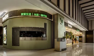 Modern Asian restaurant with green walls, a large sign, and potted plants inside