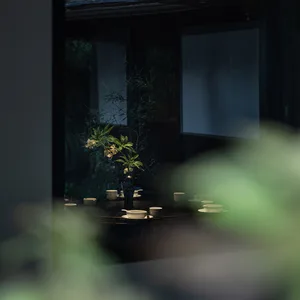 溫暖舒適的餐廳區域，設有餐桌、椅子及插花花瓶，周圍環繞植物與餐具