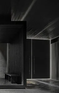 A dark hallway with a black door and a bench, creating a mysterious atmosphere