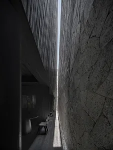 A narrow hallway with three black chairs placed along the walls, suggesting a residential or office space