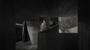 A dark and moody interior space with a spiral staircase featuring two sets of wooden stairs, creating a sense of depth and intrigue