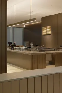 Industrial kitchen with wood and metal surfaces, featuring a countertop with various items and sinks with a coffee maker nearby