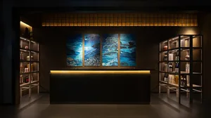Elegant restaurant interior with large paintings of water scenes above a counter bar area, sophisticated atmosphere, and tranquil ambiance