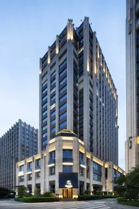 一座大型建築，融合現代與當代設計元素，以石材為主的外觀，並擁有眾多窗戶，位於城市環境中