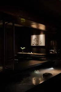 Cozy Asian restaurant interior with a wooden table, chairs, and a potted plant, creating a welcoming atmosphere