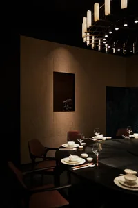 Elegant dining area with a round table, wooden ceiling, and fine china and glassware