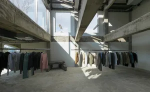 開放式服飾店設有多組衣架與長椅，展示各式服飾與配件