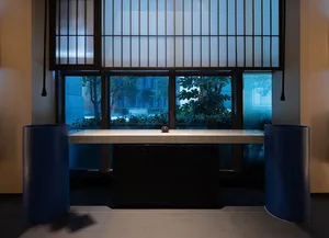 A well-lit room with a large window, two vases on a table, and a bright and inviting atmosphere