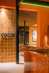 A cozy restaurant dining area with a marble countertop, brown tile walls, and various bottles placed around the room