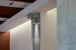 Modern interior design featuring a textured concrete block wall with two lights and a minimalist aesthetic