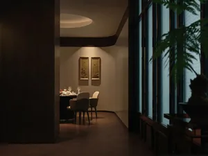 A cozy dining area with a wooden table and chairs, wine glasses, and a warm atmosphere
