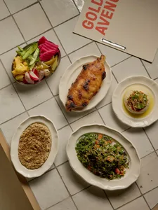 A dining table set with various plates of vegetables and bowls of food, creating a warm and inviting atmosphere