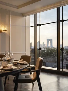 Dining area with glass window, city skyline view, fine dining elements, and comfortable seating for guests