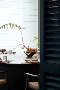 Elegant dining area with a wooden table, chairs, wine glasses, and tableware