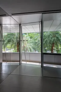 Bright indoor space with glass doors open to a patio, potted plants, and natural sunlight