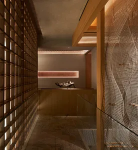 A modern hallway with a glass partition separating two rooms, featuring a wooden floor and natural light from windows on both sides