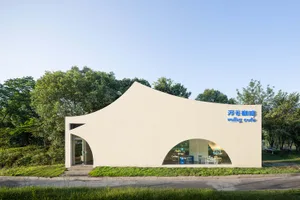 A modern building with a curved design, featuring a white exterior and a bright, inviting atmosphere