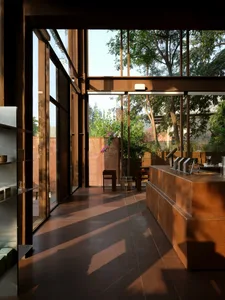 A bright and welcoming restaurant interior with large windows, multiple dining tables, and chairs, creating a comfortable atmosphere for guests