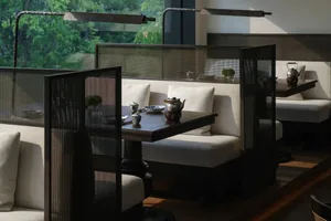 A well-lit dining area with a large table and multiple chairs, surrounded by modern decor and a stylish ambiance