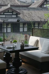 Cozy Asian-style living area with a dining table surrounded by chairs, two couches, and decorative items
