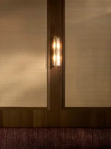 Warm living space with wood paneling, a wooden door, and a cozy couch, lit by a small lamp and another light source