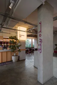 Inviting restaurant interior with Arabic writing on a wall, comfortable seating, and potted plants