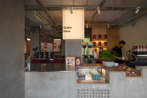 休閒餐廳櫃檯配有收銀機、杯子、瓶子和盆栽植物，為顧客營造溫馨的氛圍