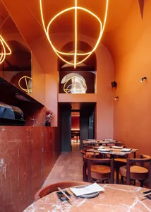 A modern restaurant with multiple dining tables and chairs, creating a comfortable atmosphere for guests