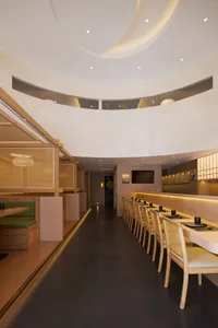 Modern restaurant interior with multiple tables, chairs, TVs, and a comfortable atmosphere