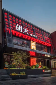 A modern Asian restaurant with a glass building, red accents, and comfortable seating areas for guests