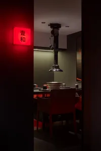 A warm and inviting Asian restaurant with red accents, wooden furniture, and multiple dining tables and chairs