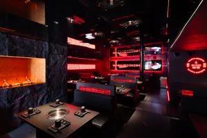 Modern restaurant dining area with multiple TV screens, tables, and chairs, creating a comfortable and inviting atmosphere