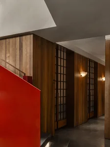 Dimly lit hallway with wooden walls and two doors, one on each side
