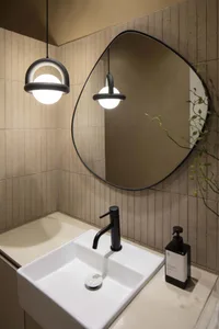 Modern bathroom with a white sink, a large mirror above, and two lights above the sink