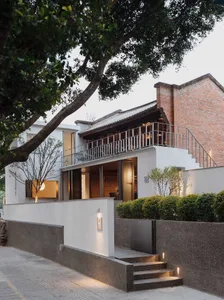 A rendered image of a house with a white exterior, a brick wall, and a red roof, featuring a patio area and conveying a sense of warmth and comfort