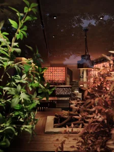Warm and inviting dining space with patterned walls, chairs, and a dining table, illuminated by natural light